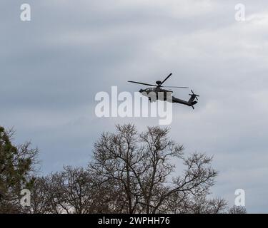 Ein Boeing AH-64F Apache Helikopter fliegt über der Luft, während Fallschirmjäger der US-Armee, die dem 1. Bataillon, 325. Airborne Infantry Regiment, 2. Brigade Combat Team, 82. Airborne Division zugewiesen sind, am 28. Februar 2024 eine Feuerübung auf Fort Liberty, North Carolina durchführen. Ziel ist es, die Taktik und den Zusammenhalt der Truppen zur Unterstützung künftiger Übungen zu validieren. (Foto der US-Armee von PFC. Montarius McGlown) Stockfoto