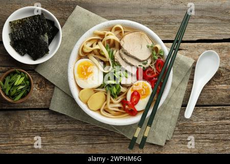 Köstliche Ramen in Schüssel serviert auf Holztisch, flach gelegt. Nudelsuppe Stockfoto