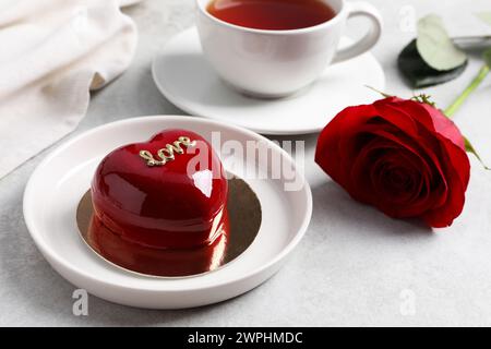 St. Valentinstag. Köstlicher herzförmiger Kuchen, serviert auf Lichttisch, Nahaufnahme Stockfoto