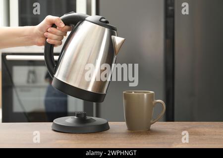 Frau mit Wasserkocher in der Küche, Nahaufnahme. Leerzeichen für Text Stockfoto