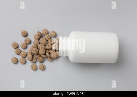 Vitaminpillen und Flasche auf hellgrauem Hintergrund, Draufsicht Stockfoto