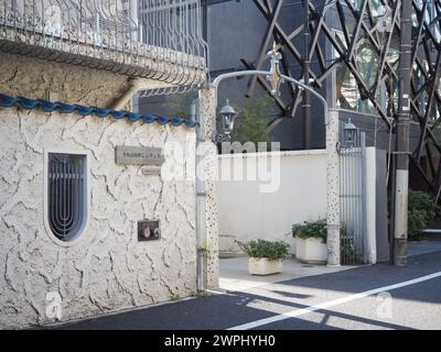 TOKIO, JAPAN - 3. März 2024: Eingang zum Apartmentgebäude aus den 1960er Jahren in Shibuya Ward's Omotesando Gegend. Daneben befindet sich ein modernes Apartmentgebäude. Stockfoto