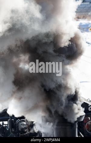 Schwarzer und weißer Rauch, der aus dem Dampfzugschornstein weht Stockfoto