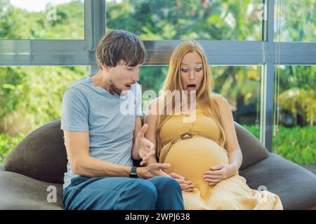 In einem entscheidenden Moment steuern die schwangere Frau und der Vater den Beginn der Kontraktionen zusammen und teilen die Intensität und die Erwartung, während sie beginnen Stockfoto