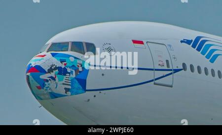 SINGAPUR - 8. MÄRZ 2024: Garuda Indonesia B777-3U3(er), PK-GIJ Ayo Pakai Masker Lackierung Endanflug zum Changi International Airport Stockfoto