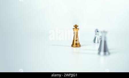 Goldenes Königsschach auf dem Brett vor silbernen Schachstücken auf weißem Hintergrund mit Kopierraum, Führung, Kämpfer, Geschäftsführung, Wettbewerb Stockfoto