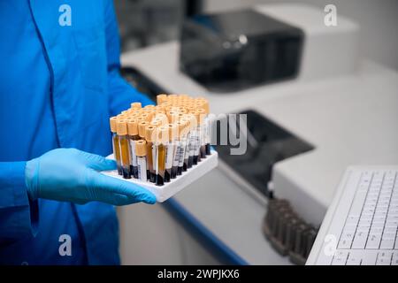 Der Forscher hält ein Set mit Reagenzgläsern in den Händen Stockfoto