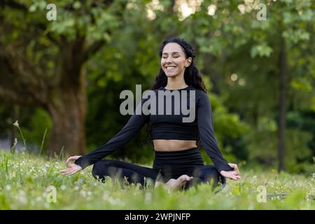 Inhalt junge Frau in Activewear genießt Yoga-Meditation im friedlichen Park und verkörpert Wellness und Achtsamkeit. Stockfoto