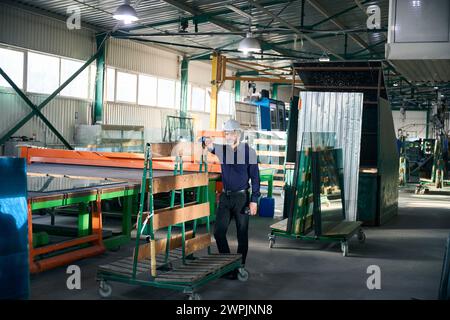 Foreman mit einem Schutzhelm steht an einem Ladewagen Stockfoto