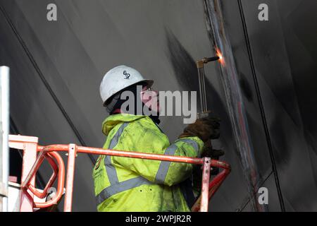 Port Glasgow, Argyll and Bute, Schottland, Großbritannien. März 2024. Aktuelle Bilder von neuen Fähren, die in der Ferguson Marine Werft in Port Glasgow am Fluss Clyde gebaut werden. Beide Fähren liegen Jahre hinter dem Zeitplan zurück und übersteigen das Budget. Foto: Arbeiter, die Arbeiten an Bugtüren von Glen Rosa durchführen, die im April 2024 eröffnet werden sollen. Iain Masterton/Alamy Live News Stockfoto