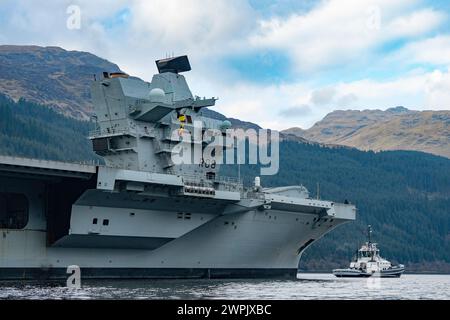 Glen Mallan, Argyll and Bute, Schottland, Großbritannien. März 2024. Die Royal Navy Flugzeugträger HMS Queen Elizabeth trifft heute in Glen Mallan auf Loch Long ein, um Munition abzuladen, bevor sie zur Rosyth Dockyard fährt, um ihre Propellerkupplungen zu reparieren. Iain Masterton/Alamy Live News Stockfoto