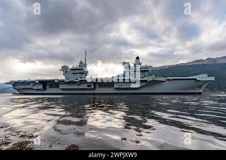 Glen Mallan, Argyll and Bute, Schottland, Großbritannien. März 2024. Die Royal Navy Flugzeugträger HMS Queen Elizabeth trifft heute in Glen Mallan auf Loch Long ein, um Munition abzuladen, bevor sie zur Rosyth Dockyard fährt, um ihre Propellerkupplungen zu reparieren. Iain Masterton/Alamy Live News Stockfoto