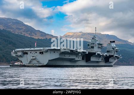 Glen Mallan, Argyll and Bute, Schottland, Großbritannien. März 2024. Die Royal Navy Flugzeugträger HMS Queen Elizabeth trifft heute in Glen Mallan auf Loch Long ein, um Munition abzuladen, bevor sie zur Rosyth Dockyard fährt, um ihre Propellerkupplungen zu reparieren. Iain Masterton/Alamy Live News Stockfoto