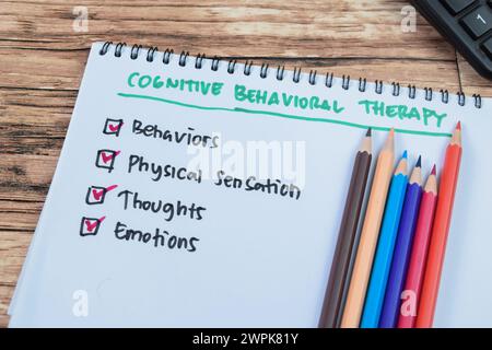 Konzept der kognitiven Verhaltenstherapie Schreiben Sie auf Buch mit Schlüsselwörtern isoliert auf Holztisch. Stockfoto