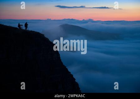 12/10/14 da ein Großteil des Landes in den frühen Morgennebel gehüllt ist, klettern Fotografen zum Gipfel des Mam Tor im Derbyshire Peak District Stockfoto