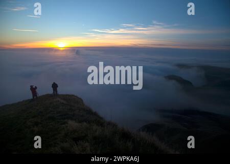 12/10/14 da ein Großteil des Landes in den frühen Morgennebel gehüllt ist, klettern Fotografen zum Gipfel des Mam Tor im Derbyshire Peak District Stockfoto