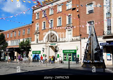 Vorderansicht der Lloyds Bank mit dem Exeter Riddle auf der rechten Seite entlang der High Street im Stadtzentrum, Exeter, Devon, Großbritannien, Europa. Stockfoto