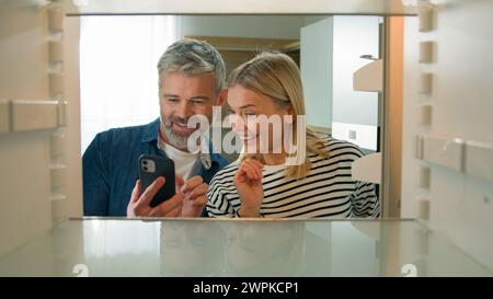 POV im Kühlschrank Kaukasische Erwachsene Familie reifes Paar Mann mittleren Alters Frau öffnet leeren Kühlschrank bestellen Lebensmittel mit mobiler Lieferung Stockfoto
