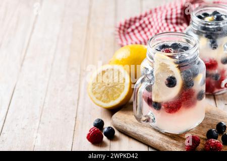 Frisches Beerengetränk mit Heidelbeeren und Himbeeren auf Holztisch Stockfoto