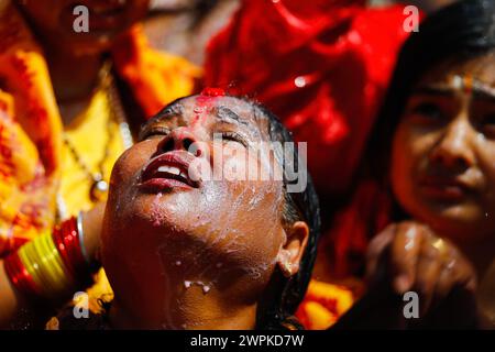 Kathmandu, Nepal. März 2024. Ein Gläubiger blickt auf einen Priester, der das Idol von Lord Shiva mit Milch schmückt und das heilige Maha Shivaratri-Festival feiert, das von Gläubigen in Kathmandu mit Eifer und Hingabe gefeiert wird. (Foto: Skanda Gautam/SOPA Images/SIPA USA) Credit: SIPA USA/Alamy Live News Stockfoto