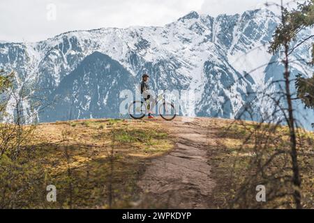 Eine Frau, die mit Bergen im Hintergrund fährt Stockfoto