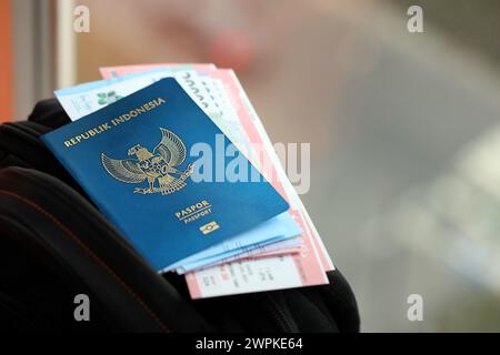 Blue Republic Indonesien Pass mit Geld und Flugtickets auf touristischen Rucksack Nahaufnahme. Tourismus und Reisekonzept Stockfoto