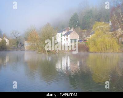 Neblige Morgensonne am Cromford Mühlenteich im Derbyshire Peak District, Großbritannien Stockfoto