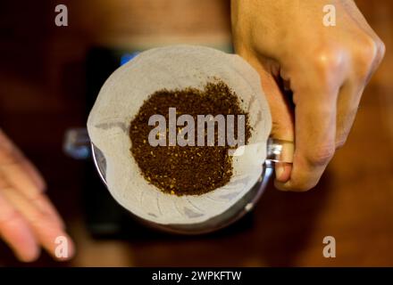 V60 Filterkaffee mit Händen an der Bar Stockfoto