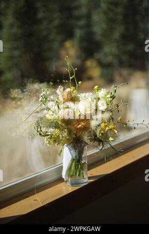 Wunderschöner Hochzeitsstrauß aus Blumen sitzt im Glasgefäß Stockfoto