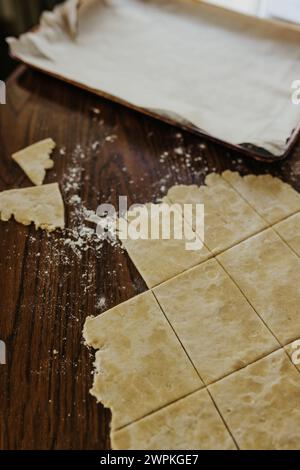 Frisch ausgerollte und in Scheiben geschnittene Sauerteigkruste auf dem Küchentisch Stockfoto