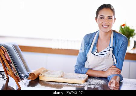 Porträt, Lächeln zum Backen und Frau in der Küche von zu Hause mit Teig, Mehl oder Gebäck Zutaten für Brot oder Kuchen. Essen, Rezept und Herd mit Happy Stockfoto