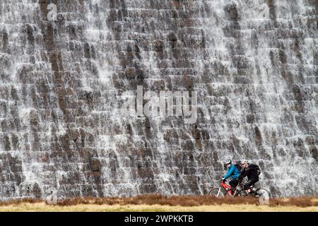 27/02/15 Radfahrer werden von Tausenden von Liter Wasser aus geschmolzenem Schnee und Tagen mit starkem Regen, der über den Derwent Dam hinunter in den Jungen fließt, in den Schatten gestellt Stockfoto