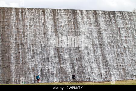 27/02/15 Radfahrer werden von Tausenden von Liter Wasser aus geschmolzenem Schnee und Tagen mit starkem Regen, der über den Derwent Dam hinunter in den Jungen fließt, in den Schatten gestellt Stockfoto