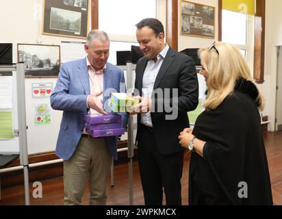 Taoiseach Leo Varadkar (Mitte) und Fine Gael Senatorin Mary Seery Kearney schenken Joe Burke, dem Wahlleiter der Stadt Dublin, Süßigkeiten und Bars in Scoil Treasa Naofa, Donore Avenue, Dublin, Irland führt Referenden über die vorgeschlagenen Änderungen des Wortlauts der Verfassung in Bezug auf die Bereiche Familie und Pflege durch. In dem Änderungsantrag zur Familie wird vorgeschlagen, die Bedeutung der Familie über die Definition der Ehe hinaus auszudehnen und auf solche, die auf "dauerhaften" Beziehungen beruhen, einzubeziehen. Der Pflegezusatz schlägt vor, Verweise auf die Rollen und Pflichten einer Frau zu Hause zu streichen und zu ersetzen Stockfoto