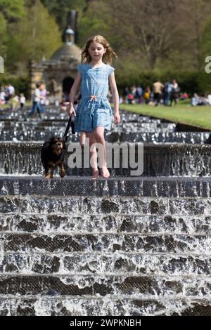 05/15 Isabella Coleman (9) und ihr Kavalier King Charles, Emily, kühlen sich in der Kaskade ab, während die Menschen strömen, um das Wetter am Montag der Bank zu genießen Stockfoto