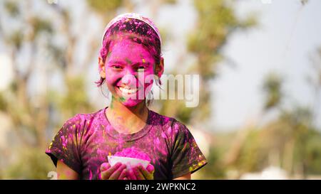 Kind weht holi Farbe Pulver aus der Hand während Holi Festival Feier - Konzept der kleinen Kinder, die Spaß am Spielen haben holi während der festlichen Stockfoto