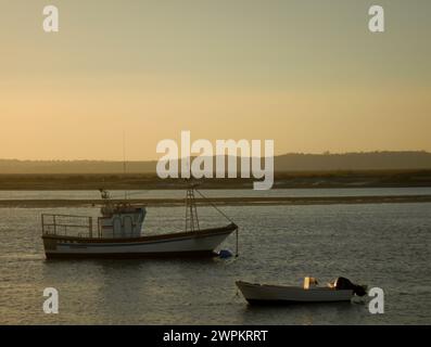 Boote, die bei Sonnenuntergang am Strand ankern Stockfoto