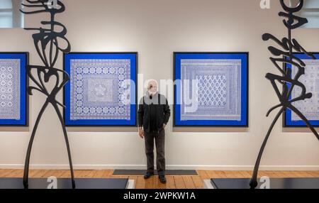 Oktober Gallery, London, Großbritannien. März 2024. Celestial Blue ist eine Einzelausstellung neuer Werke des algerischen Künstlers Rachid Koraichi (Foto). Ausgehend von den komplizierten Texten der arabischen Schrift, oft in umgekehrter oder spiegelter Schrift, setzt Koraichi Symbole, Zahlen und Chiffren ein, die aus einer Vielzahl von Sprachen und kulturellen Traditionen stammen. Die Ausstellung vom 7. März bis 13. April umfasst Leinwandarbeiten, durchsetzt mit statuesken Stahlskulpturen aus der Serie Les Vigilants (II), 2020, in seinen charakteristischen figurativen Formen. Die Leinwände sind von den Nasibs inspiriert, die die 12 sind Stockfoto