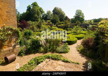 Im formellen Ladys Garden hinter Broughton Castle; Wasserschloss mit dem Schloss Banbury, Oxfordshire am Sommertag mit blauem Himmel. UK. (134) Stockfoto