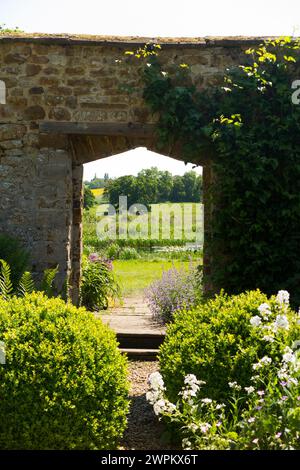 Im formellen Ladys Garden hinter Broughton Castle; Wasserschloss mit dem Schloss Banbury, Oxfordshire am Sommertag mit blauem Himmel. UK. (134) Stockfoto