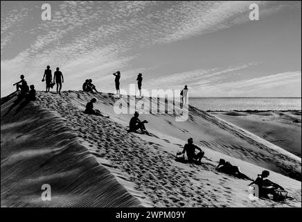 DÜNEN MASPALOMAS B&W MENSCHEN SILHOUETTE RUHE B&W KUNST EVOKATIVE LANDSCHAFT KÜNSTLERISCHE DÜNEN RETRO URLAUB zeitlos, gemäßigt, B&W Kunst Landschaft Bild einer surrealen einzigartigen Anordnung von Menschen auf dem Kamm einer Sanddüne, in Maspalomas Dünen im Süden Gran Canaria Kanarischen Inseln Spanien. Stockfoto