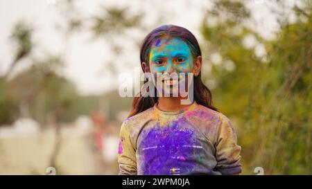 Kinder, die während des Festivals von Holi mit farbigem Pulver bedeckt waren. Glückliche süße asiatische Kinder feiern das indische holi-Festival mit farbenfrohem Farbpulver auf fac Stockfoto