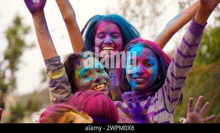 Fröhliche indische Kinder spielen Farben, lächeln mit Farben im Gesicht oder asiatische Kinder feiern Holi. Konzept für das indische Festival Holi. Helle Kinder verschmieren Stockfoto