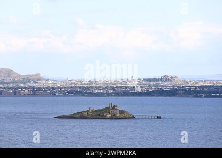 Blick auf die Skyline von Edinburgh vom Firth of Forth. Die Insel Inchmickery liegt im Vordergrund und die Burg dominiert die Skyline. Stockfoto