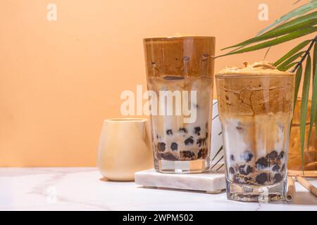 Boba dalgona Kaffee. Trendiges asiatisches Latte-Morgengetränk mit Instant-Kaffee und Tapioka-Perlkugeln, thailändisches Schaumcocktail-Glas im Sommer in der Sonne Stockfoto