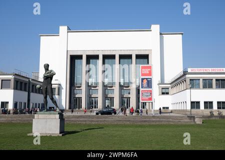 Dresden, Deutschland. März 2024. Passanten vor dem Deutschen Hygiene-Museum (DHMD) mit dem Ball Thrower von Richard Daniel Fabricius. Die Sonderausstellung VEB Museum - das Deutsche Hygiene-Museum in der DDR (9. März bis 17. November 2024) widmet sich der eigenen Geschichte des Museums von der Nachkriegszeit bis in die 1990er Jahre Quelle: Sebastian Kahnert/dpa/Alamy Live News Stockfoto