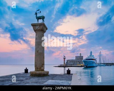 Hirsch und Hirsch auf Säulen am Eingang zum Hafen von Mandraki, ehemaliger Ort des Kolosses von Rhodos, Festung St. Nikolaus im Hintergrund, Sonnenaufgang, R. Stockfoto