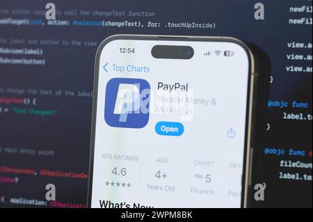 New York, USA - 23. Februar 2024: PayPal auf dem iphone-Bildschirm mit unscharfem Code-Programmierhintergrund Stockfoto