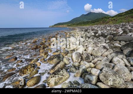 Batan, Philippinen. März 2024: Chadpidan Boulder Beach in Basco & Mount Iraya in Batanes, der nördlichsten Insel des Landes, die nächste ist 142 km vom südlichsten Punkt Taiwans entfernt. PH Navy verstärkt die Truppenpräsenz auf strategisch gelegenen Inseln mit 119 neuen Reservisten + 76 Rekruten in Ausbildung, ein unangenehmer Einsatz für Peking, der Manila beschuldigt, mit Feuer gespielt zu haben. 2023 genehmigte Pres Marcos den amerikanischen Zugang zu vier weiteren philippinischen Militärbasen (EDCA), von denen drei auf Taiwan ausgerichtet sind. Die US-Militärs werden 2024 Balikatan Marineübungen in Batanes durchführen. Quelle: Kevin Izorce/Alamy Live News Stockfoto