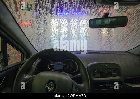Mietwagen in einer Autowaschanlage. Blick vom in einem Auto, wie sie durch eine automatische Waschanlage fortschreitet. Stockfoto